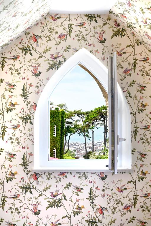 a window in a room with floral wallpaper at Domaine Saint Clair - Le Donjon in Étretat
