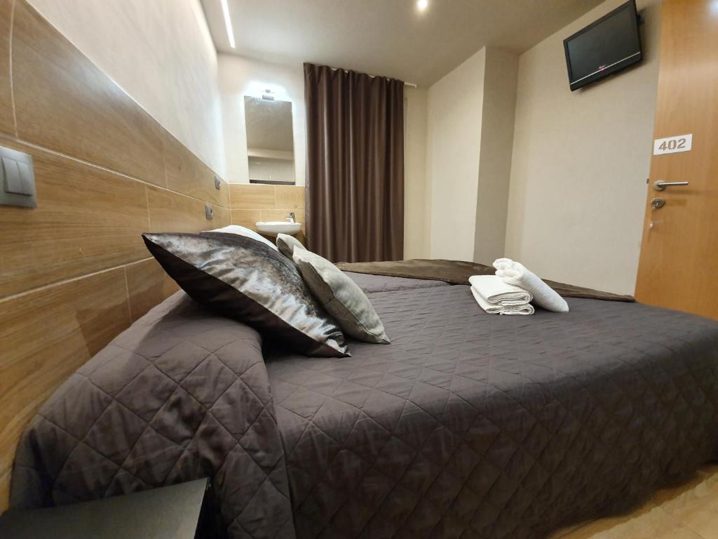 Habitación de hotel con cama con almohadas y teléfono en Pensión San Ramón, en Barcelona