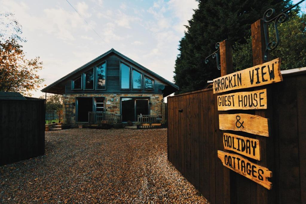 a house with a fence with signs in front of it at Crackin View Guest House in Hexham