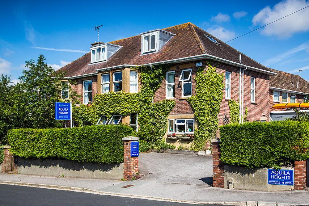 uma grande casa de tijolos com hera a crescer nela em Aquila Heights Guest House em Dorchester