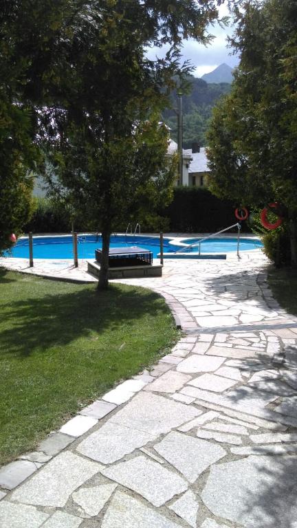 a stone path leading to a swimming pool with a bench at Coma de Alba Benasque in Benasque