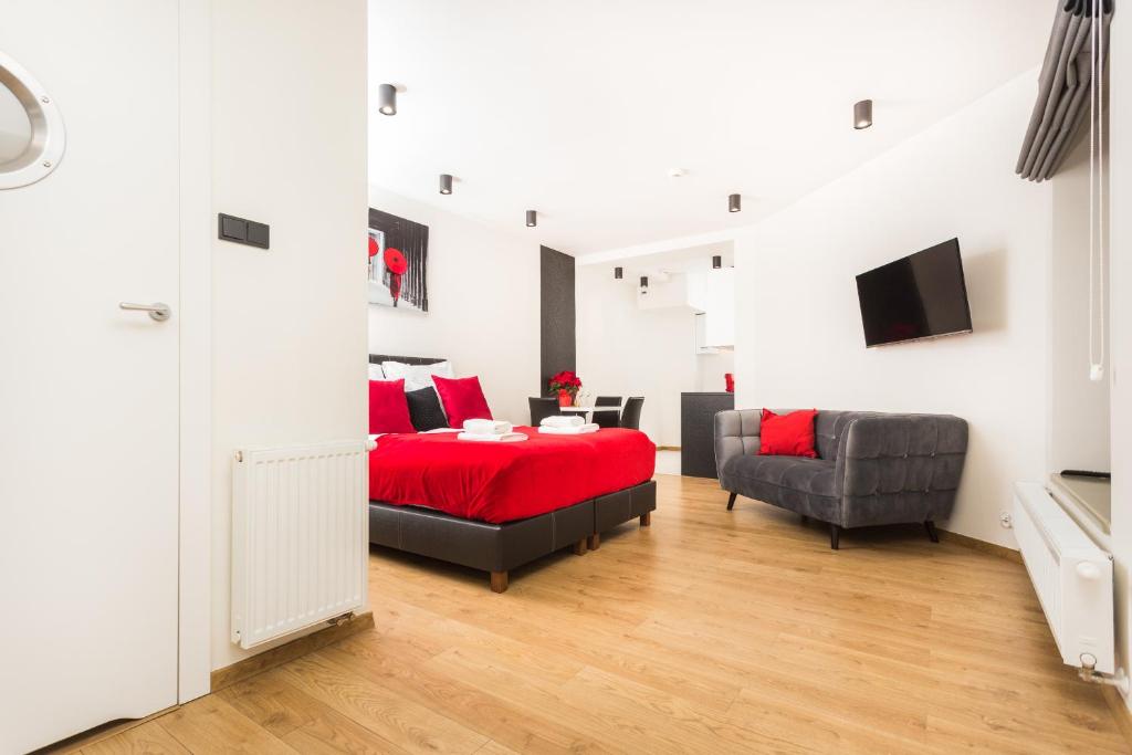 a bedroom with a red bed and a chair at Krupnicza Apartment - 5 minut from Main Square by INPOINT CRACOW in Krakow