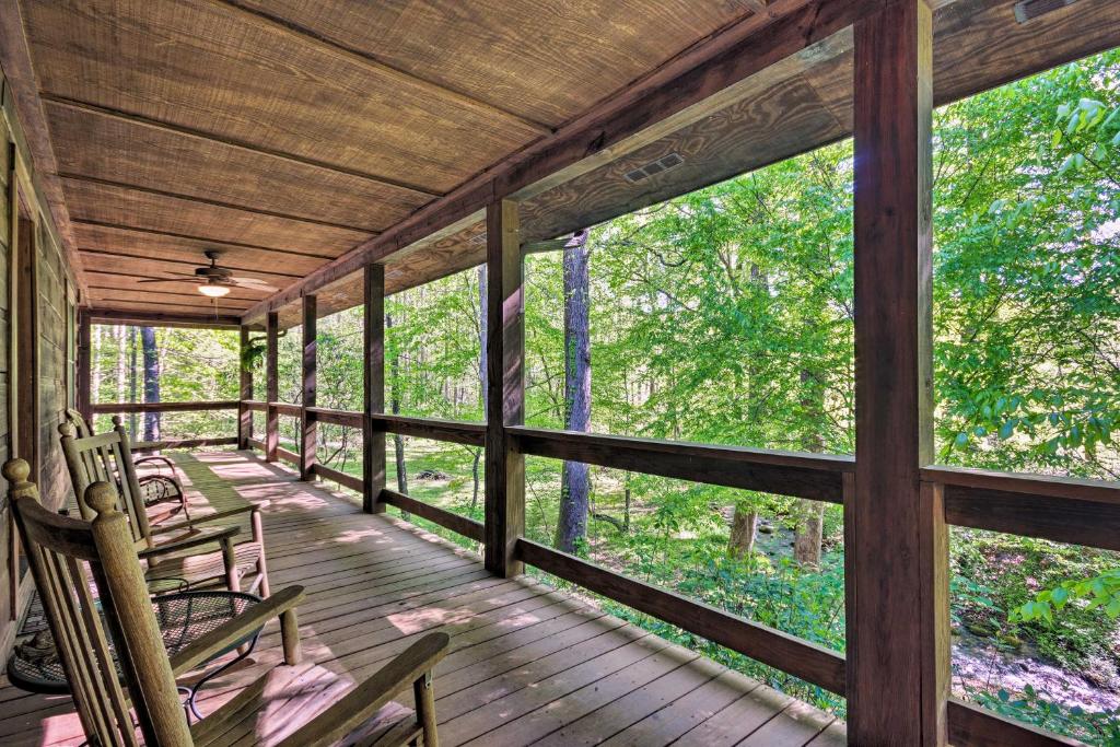 un porche de una cabaña con sillas y árboles en Creekside Marietta Cabin Retreat with Fire Pit! en Marietta