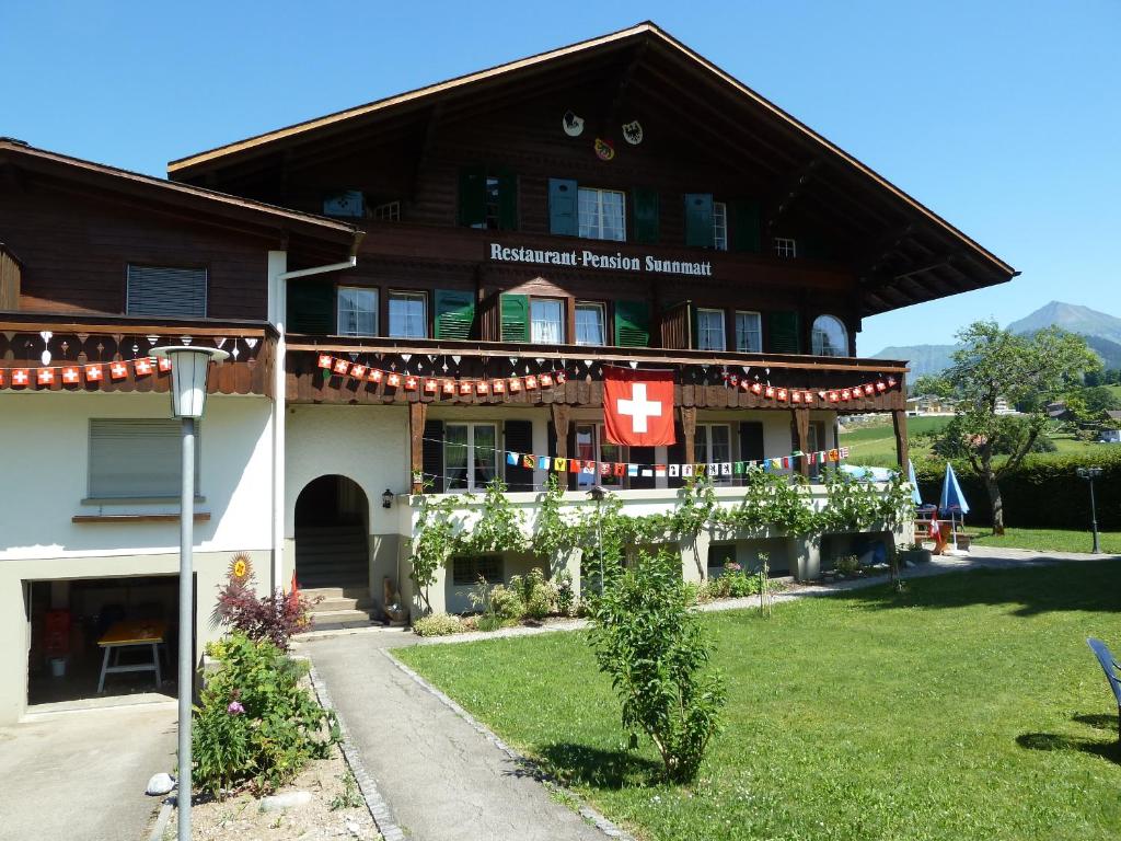 a building with a flag on the front of it at Hotel Restaurant Sunnmatt in Aeschi