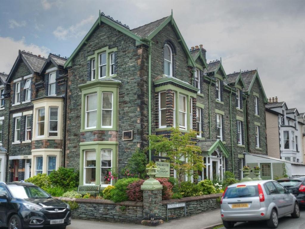 a large brick house with cars parked in front of it at Dalkeith Guest House in Keswick