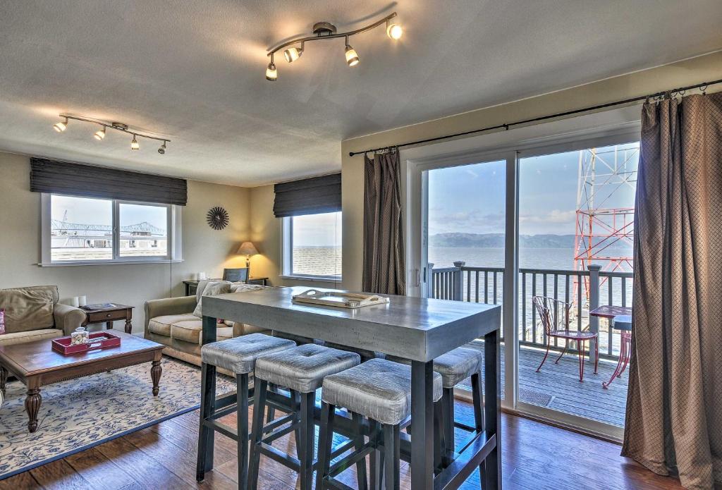 uma sala de estar com uma mesa e vista para o oceano em Waterfront Condo on Pier in Downtown Astoria! em Astoria