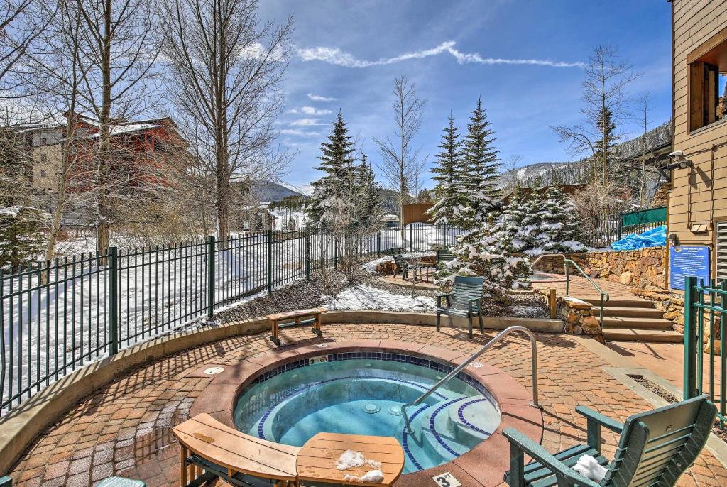 a hot tub with a bench and a fence at Cozy Ski-In and Ski-Out Winter Park Resort Condo! in Winter Park