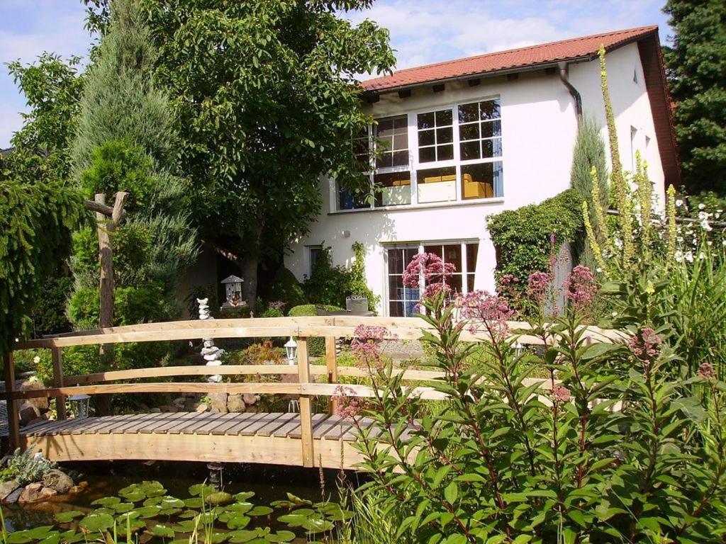 a wooden bridge in a garden in front of a house at Ferienhaus-Weitblick in Wohlau