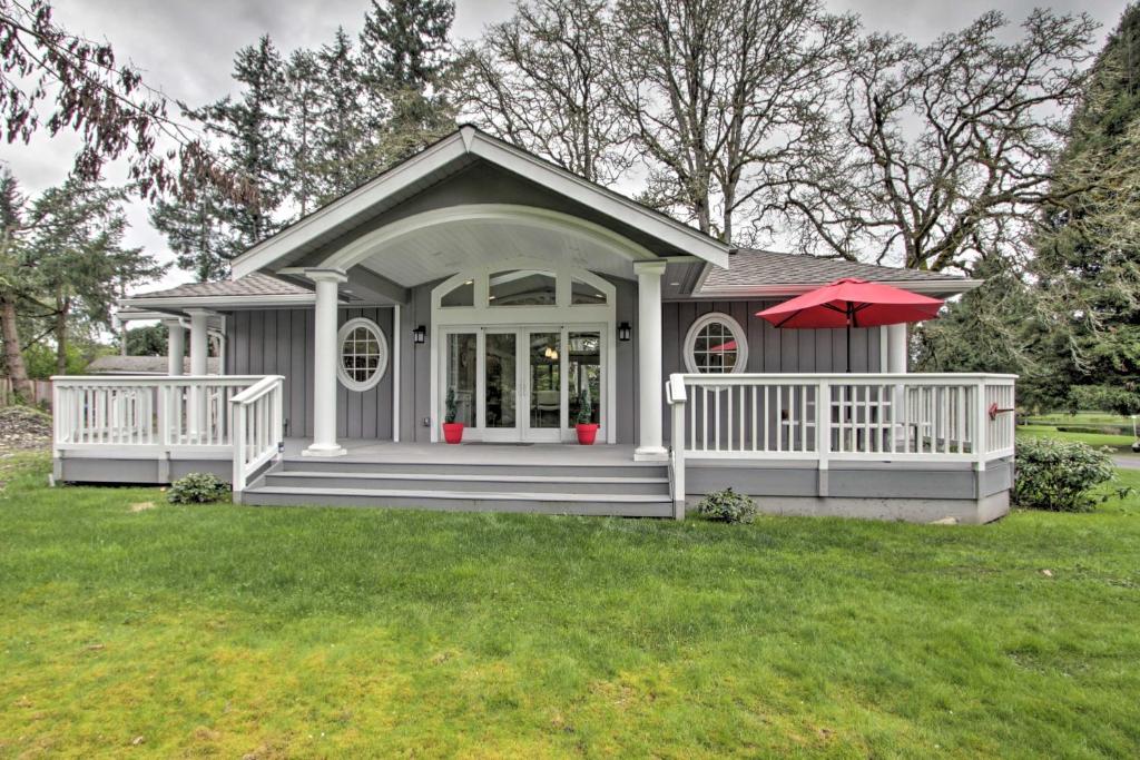 塔科馬的住宿－Contemporary Tacoma Cottage with Deck and Pond!，一座带门廊和红色雨伞的小房子