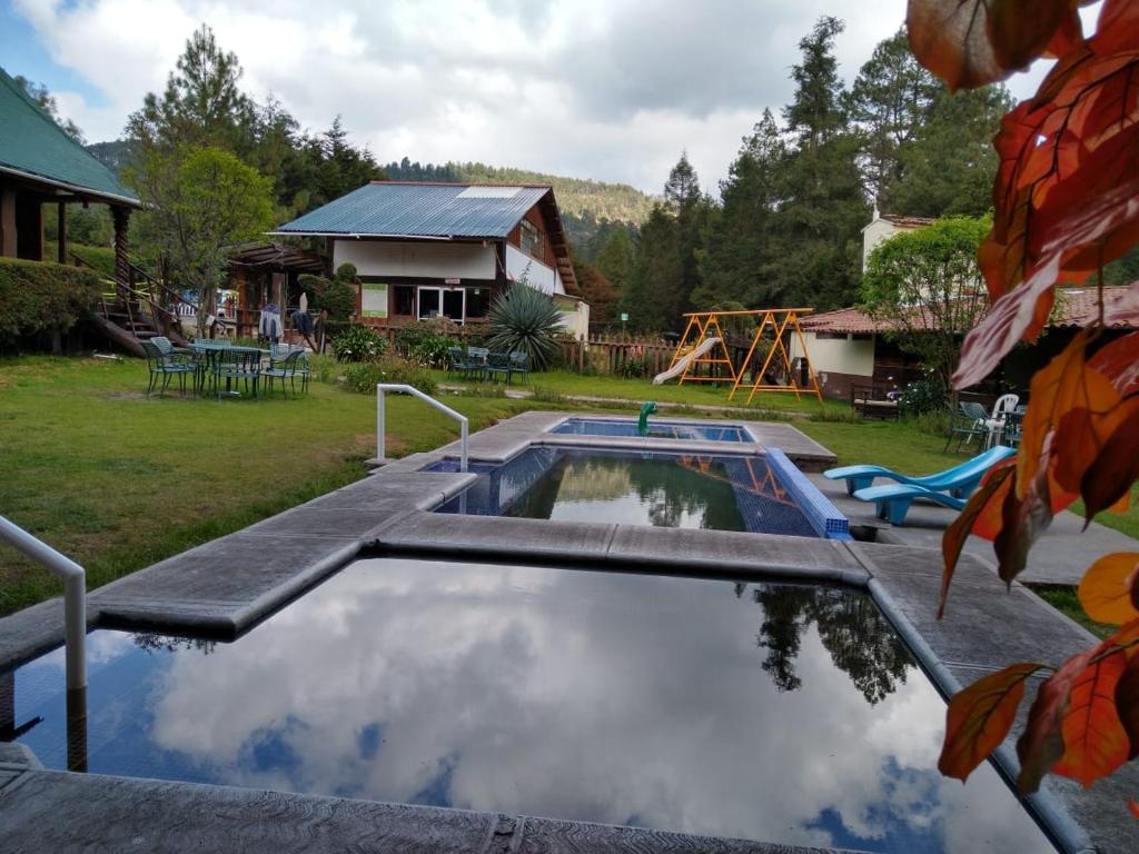 a large pool of water in front of a house at Club Tejamaniles in Los Azufres