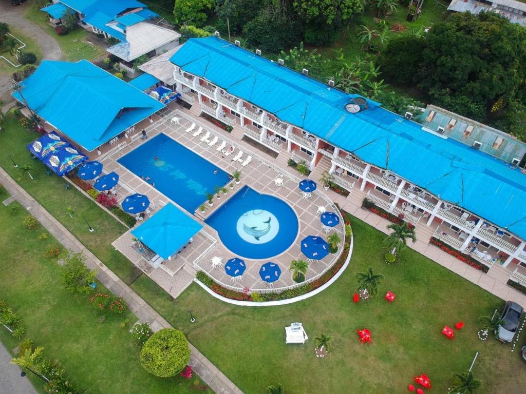 an aerial view of a resort with a pool and blue umbrellas at Hotel & Resort Villa del Sol in Tumaco