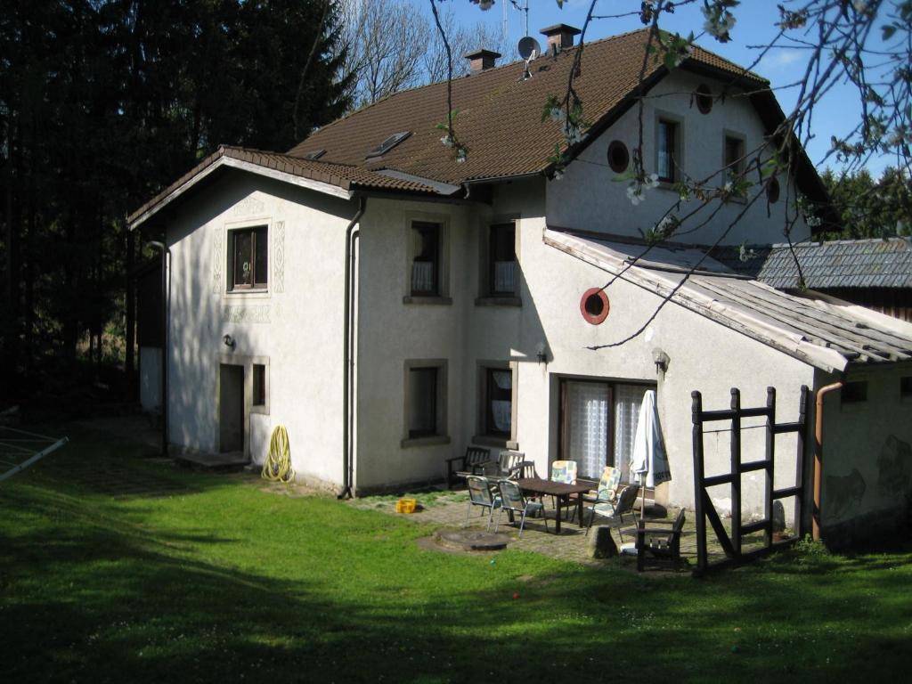 a white house with a picnic table in front of it at Zigeunermühle in Weißenstadt