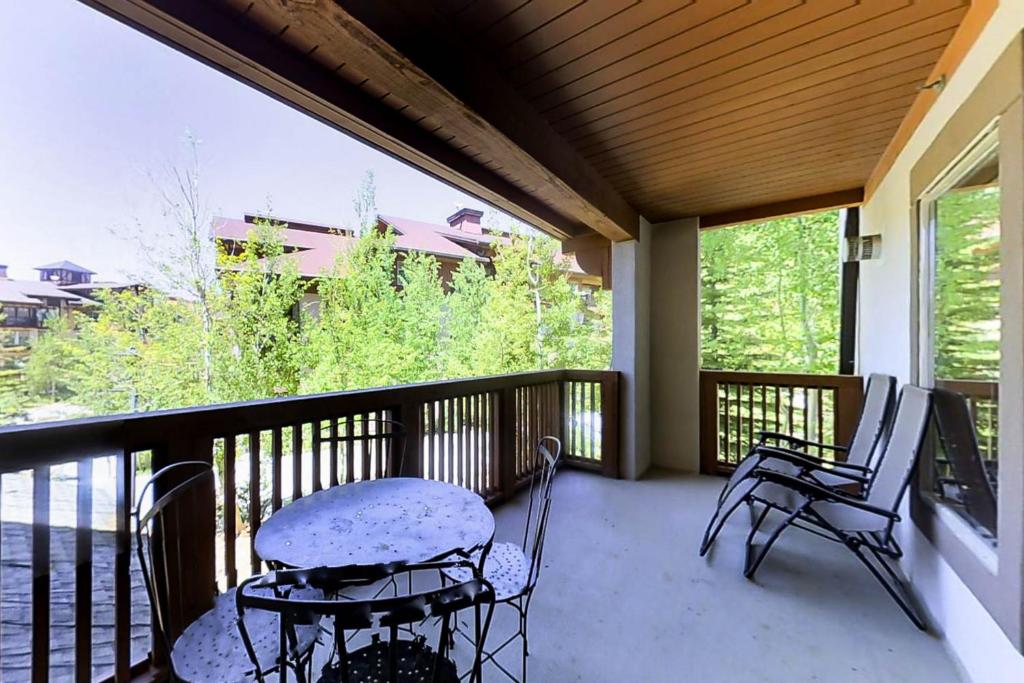un porche con 2 sillas y una mesa en el balcón en Powderhorn Lodge 210: Blazing Star Suite en Solitude