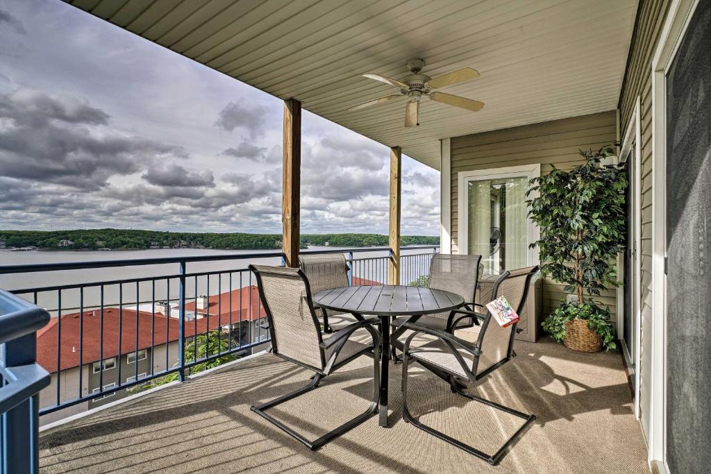 a patio with a table and chairs on a balcony at Waterfront Lake Ozark Condo with Deck and Pools in Lake Ozark