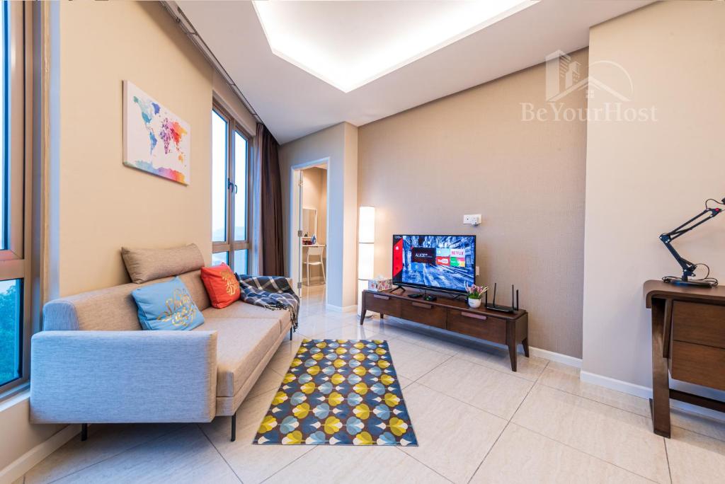 a living room with a couch and a tv at Dorsett Residences Sri Hartamas [5 Star Suites] in Kuala Lumpur