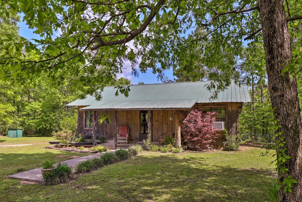 a cabin in the woods with a tree at Secluded Cabin with Pond - 37 Mi to Gulf Coast! in Wiggins