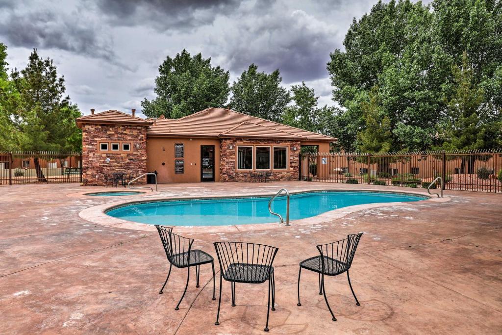 a swimming pool with two chairs and a house at Lovely Kanab Condo in Dwtn, 30 mi to Zion NP! in Kanab