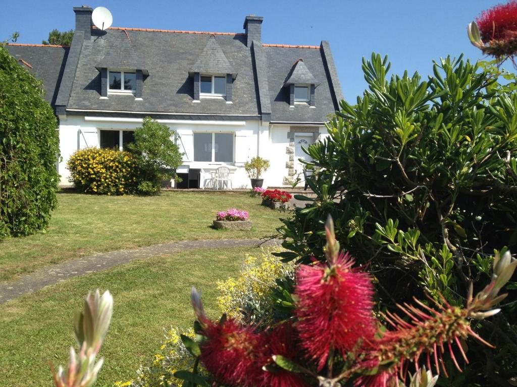 une grande maison blanche avec un jardin en face de celle-ci dans l'établissement Regard bleu sur horizoN, à Trégunc