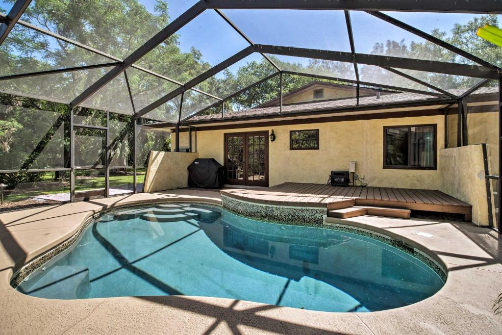 a swimming pool in a house with a glass roof at Relaxing Riverfront Oasis 5 Mi to Satellite Beach in Merritt Island