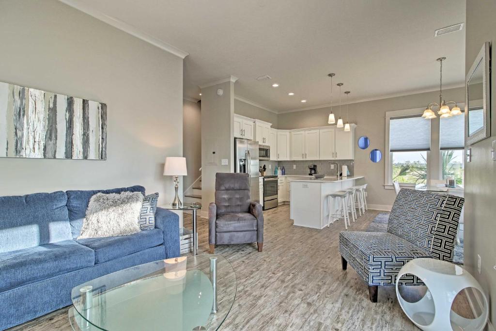 Il comprend un salon avec un canapé bleu et une cuisine. dans l'établissement Cottage with Shared Pool, 2-Block Walk to Beach!, à Gulf Shores