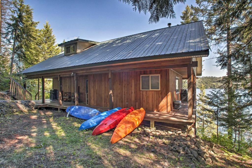 a small cabin with four kayaks in front of it at Swim, Boat and Explore! South Lake Coeur dAlene Gem in Worley