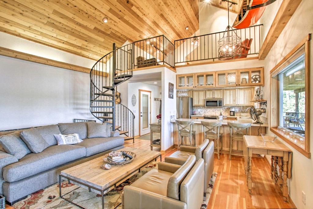 a living room with a couch and a spiral staircase at South Lake Coeur dAlene Home with Dock and Kayaks! in Worley