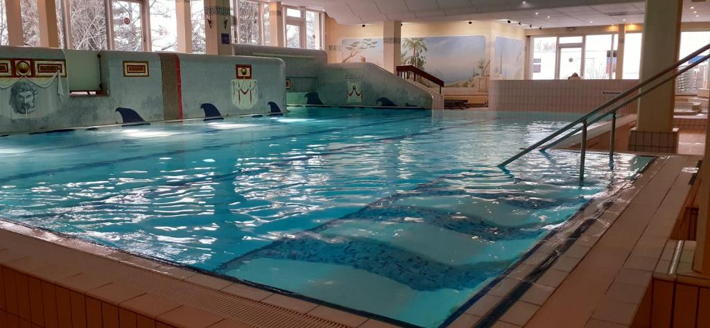 uma grande piscina interior com água azul em Ferienwohnung Falkennest em Sankt Englmar