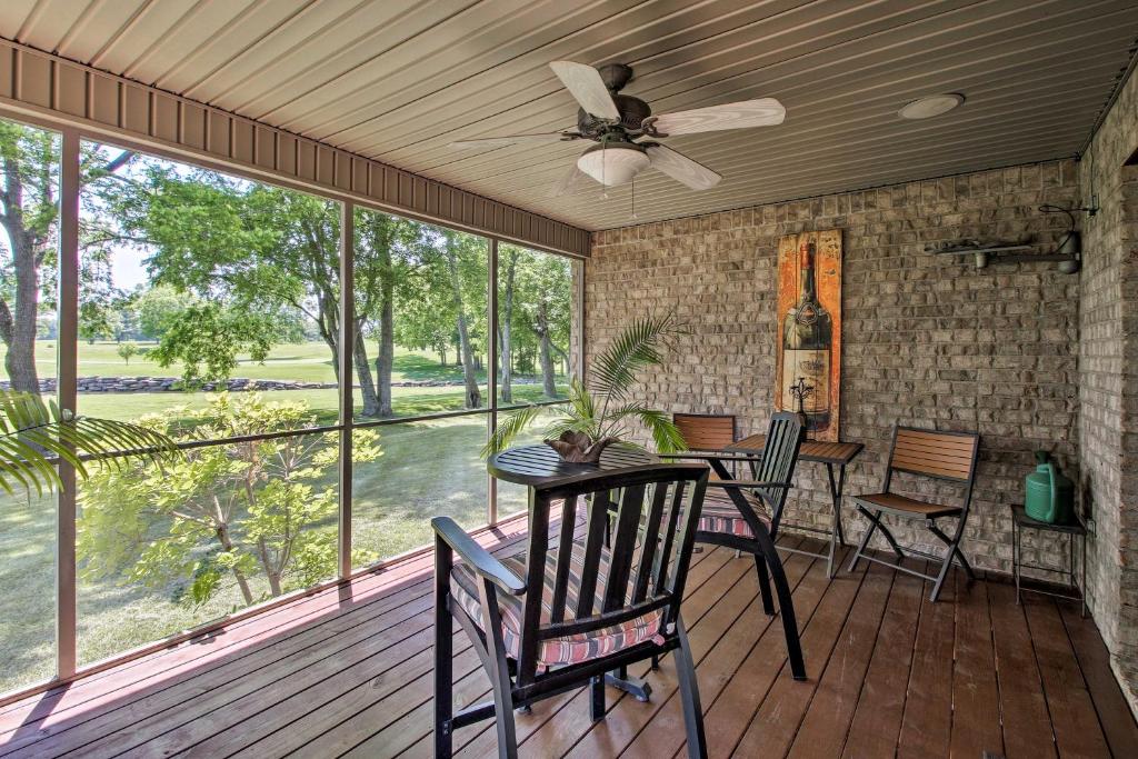 een afgeschermde veranda met een tafel en stoelen en een plafondventilator bij Gallatin House on Long Hollow Golf Course! in Gallatin