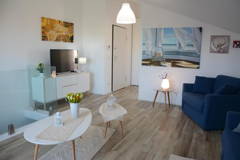 un soggiorno con divano blu e tavolo di ATTICO MARIS 104 a due passi dalla spiaggia Free Wi Fi ad Alghero