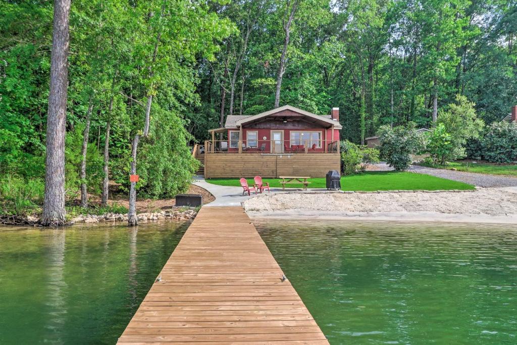 una cabina sulla riva di un lago con un molo in legno di Waterfront Lake Martin Home with Grill and Beach! a Eclectic
