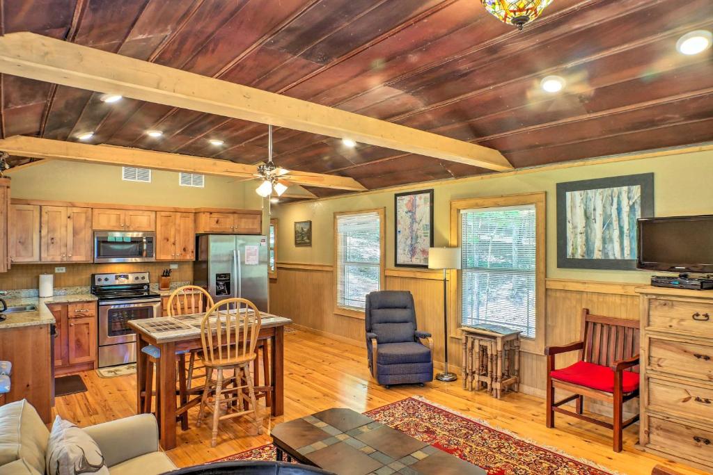 a living room with wooden ceilings and a kitchen at Guntersville Lake Cabin with 3 Fishing Ponds! in Guntersville