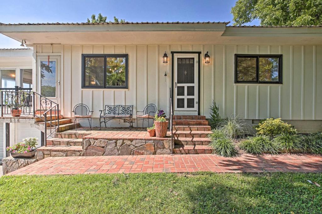 Una casa con un porche con un banco. en Charming Summerville Home with Yard and Sunroom!, en Summerville