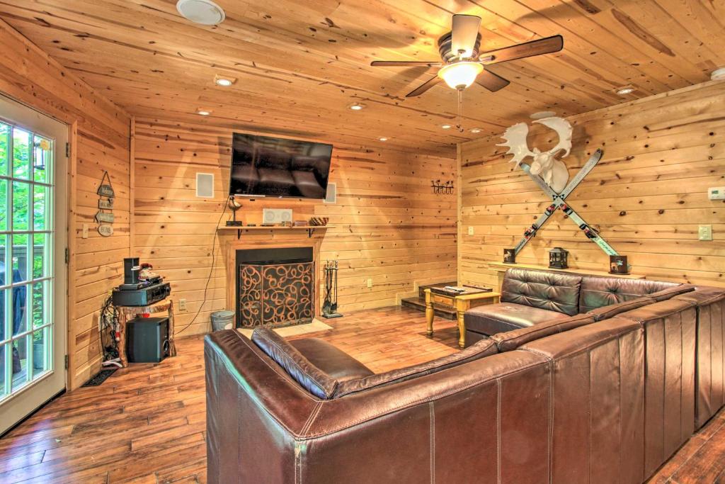 a living room with a couch and a ceiling fan at Rustic Gatlinburg Chalet with Hot Tub 2 Mi to Town in Gatlinburg