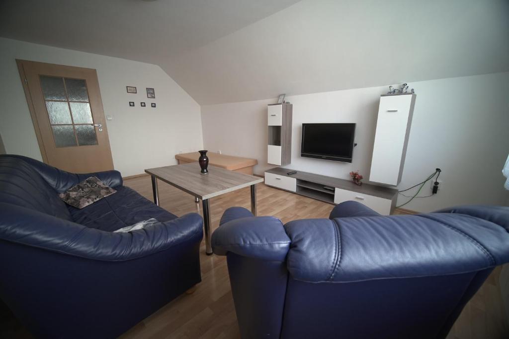 - un salon avec deux chaises bleues et une table dans l'établissement Apartment Imka, à Lúčky