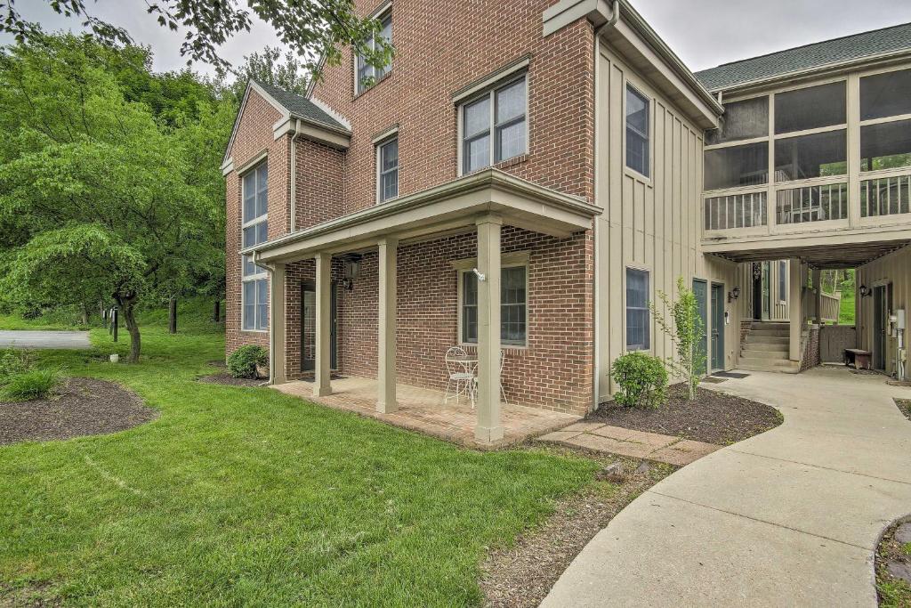 a brick house with a porch and a yard at Spacious Mercersburg Home at Whitetail Resort in Clear Spring