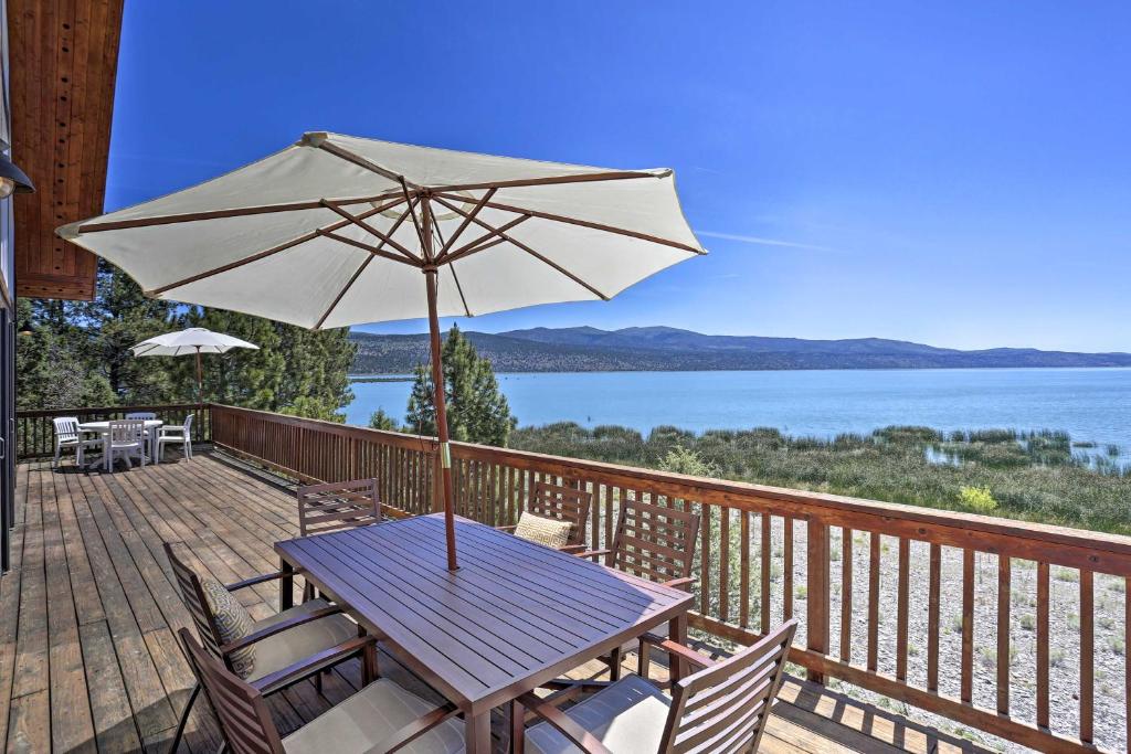 a wooden deck with a table and an umbrella at Scenic Susanville Cabin with Deck on Eagle Lake in Susanville