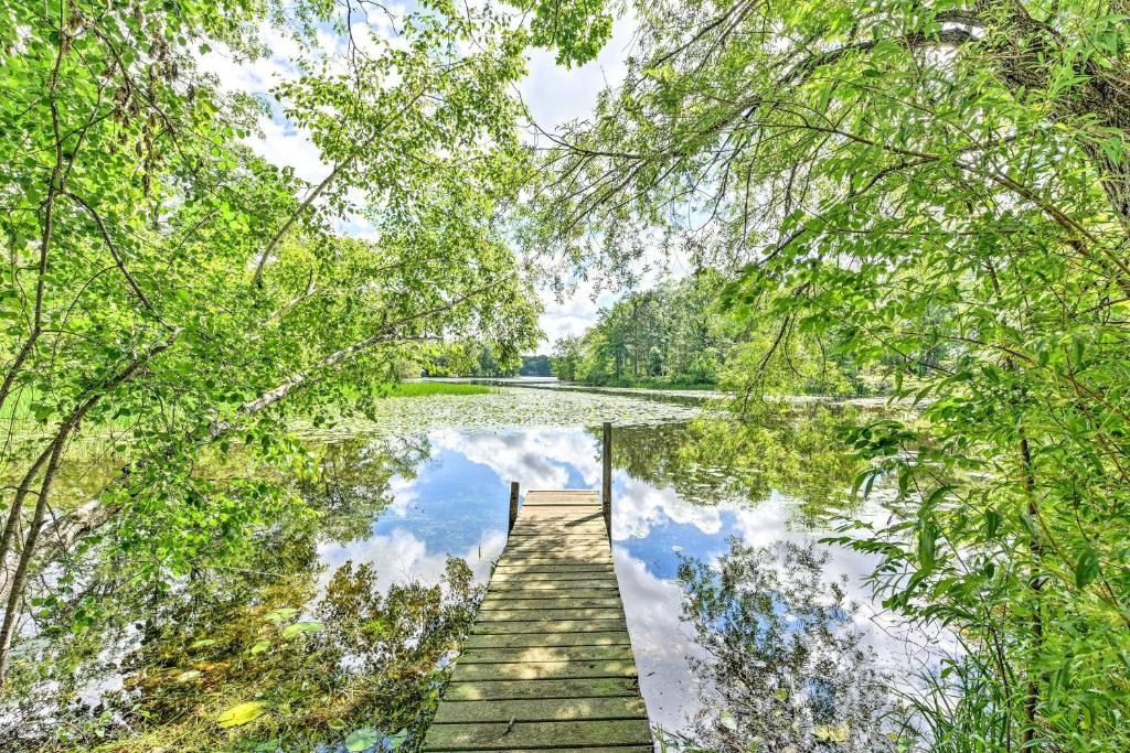 a wooden dock in the middle of a lake at Fishermens Paradise with Fire Pit on Rice Lake! in Rice Lake