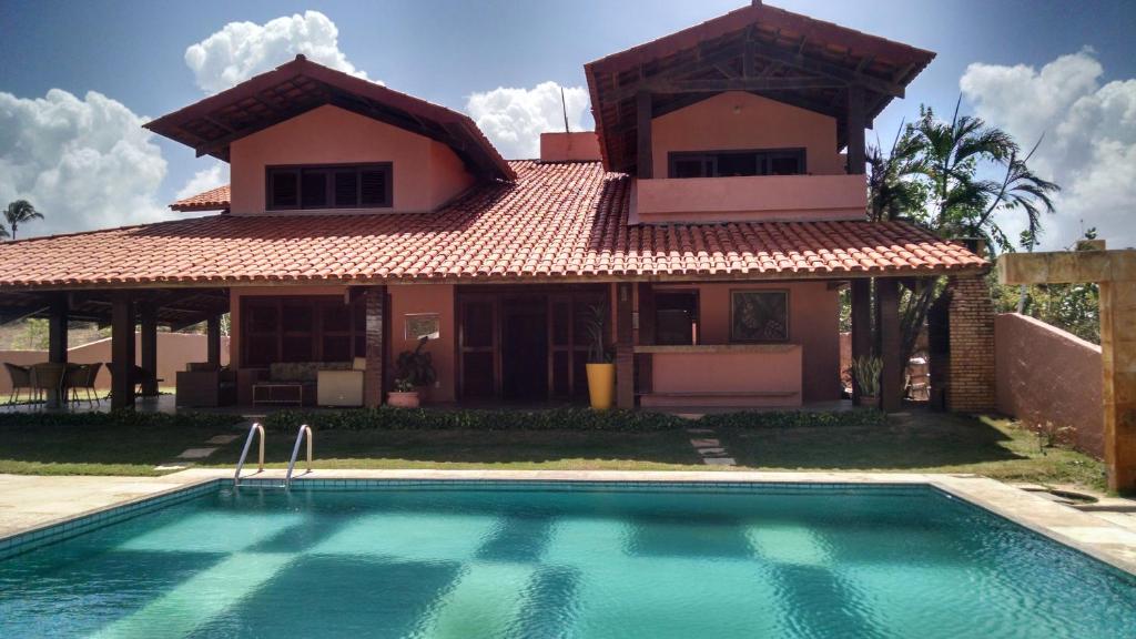 una casa con piscina frente a una casa en Casa do Cumbuco, en Cumbuco