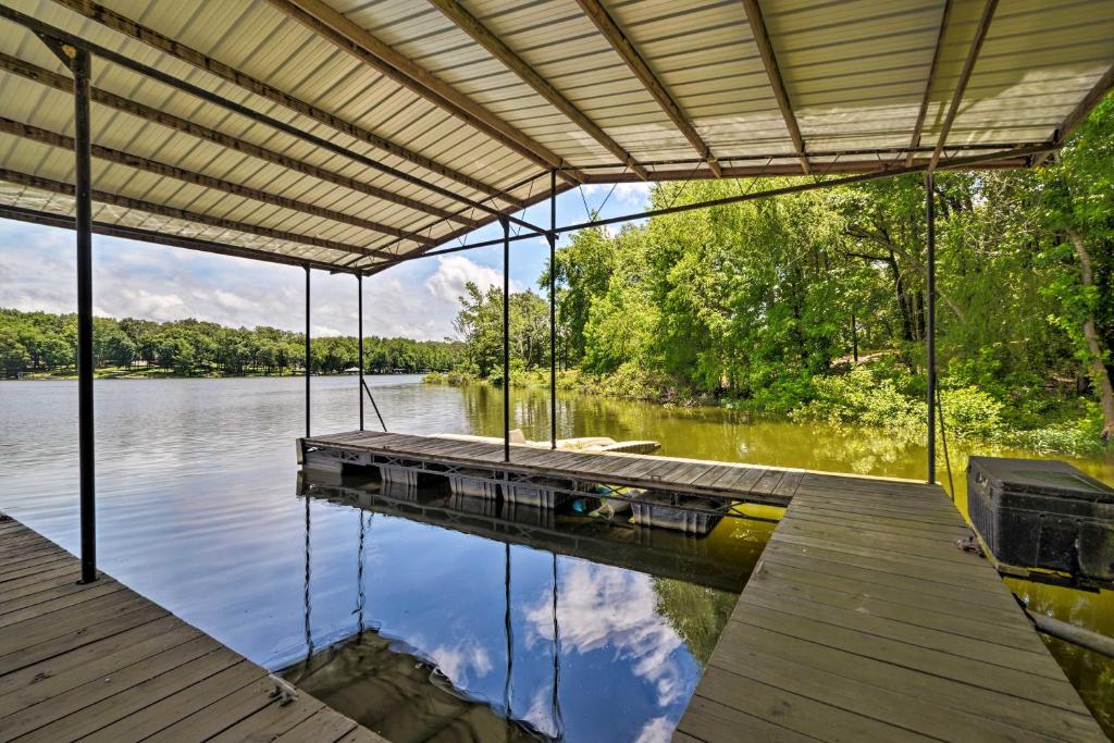 een dok op een meer met een reflectie in het water bij Waterfront Lake Barkley Home with Deck and Fire Pit! in Cadiz