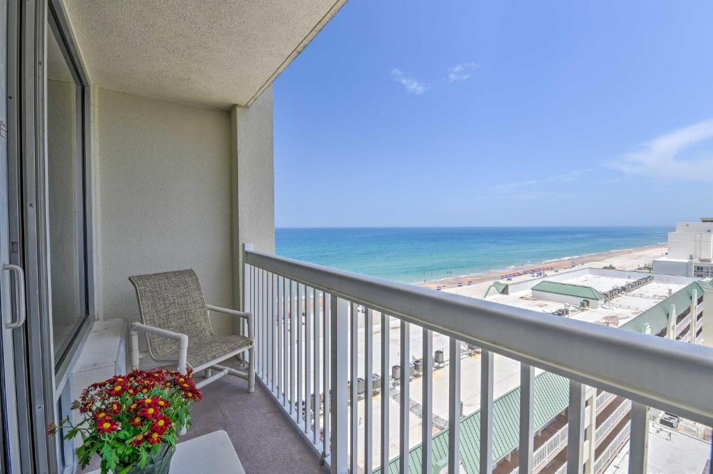 a balcony with a table and a chair and the ocean at Daytona Beachfront Condo with Ocean View in Daytona Beach