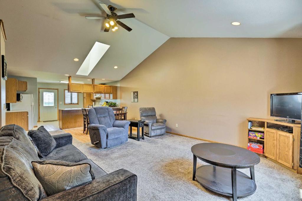 a living room with a couch and a tv at Elwood Townhome with Patio - 7 Mi to Johnson Lake in Elwood