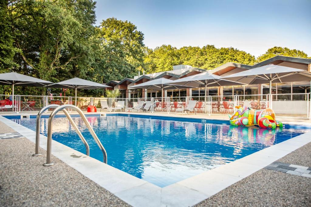 einen Pool in einem Resort mit einer aufblasbaren Rutsche in der Unterkunft Kyriad Montchanin le Creusot in Montchanin