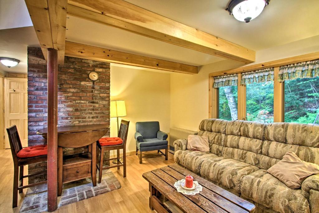 uma sala de estar com um sofá e uma parede de tijolos em Waterfront Rumney Cabin with Stinson Lake Access em Rumney