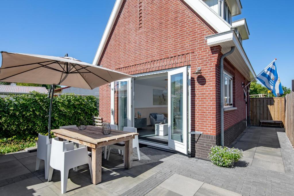 patio con tavolo in legno e ombrellone di Willem a Zoutelande