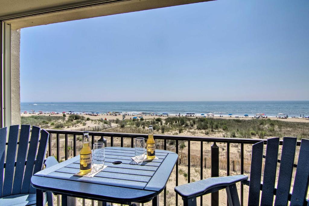 een blauwe tafel en stoelen op een balkon met uitzicht op het strand bij Beachfront Ocean City Condo with Balcony and Views in Ocean City