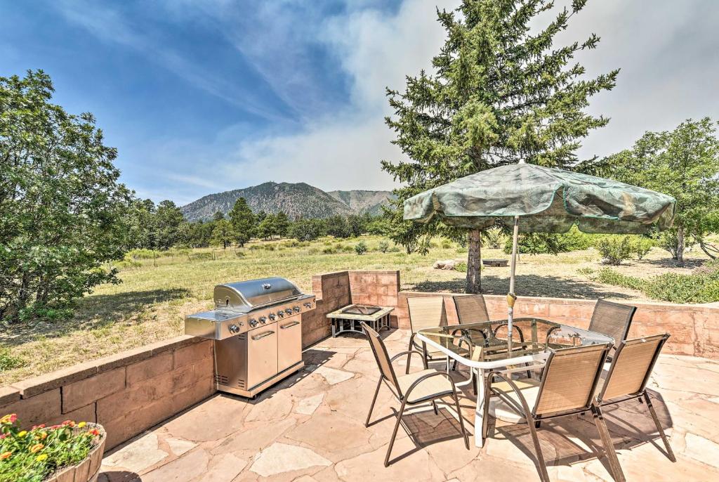 un patio con parrilla, mesa y sillas en Lovely Flagstaff Home with BBQ Area and Mtn Views!, en Flagstaff