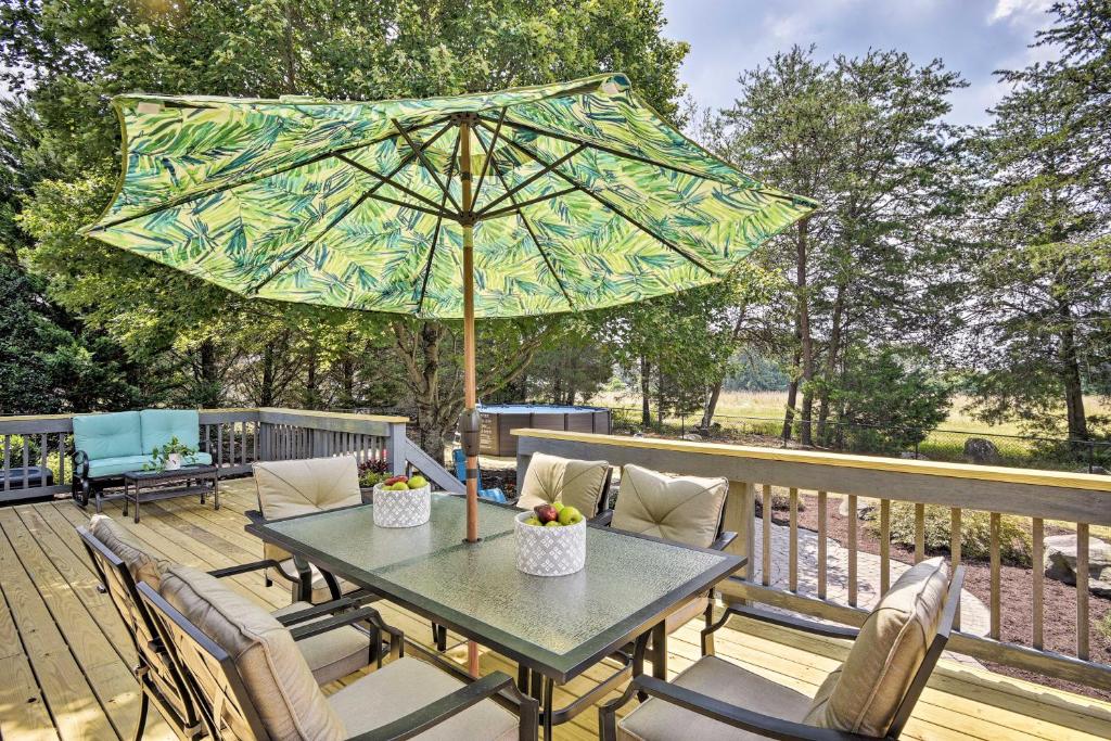 a patio table with an umbrella on a deck at 1-Acre Family Home with Pool about 11 Mi to Greensboro in Monticello