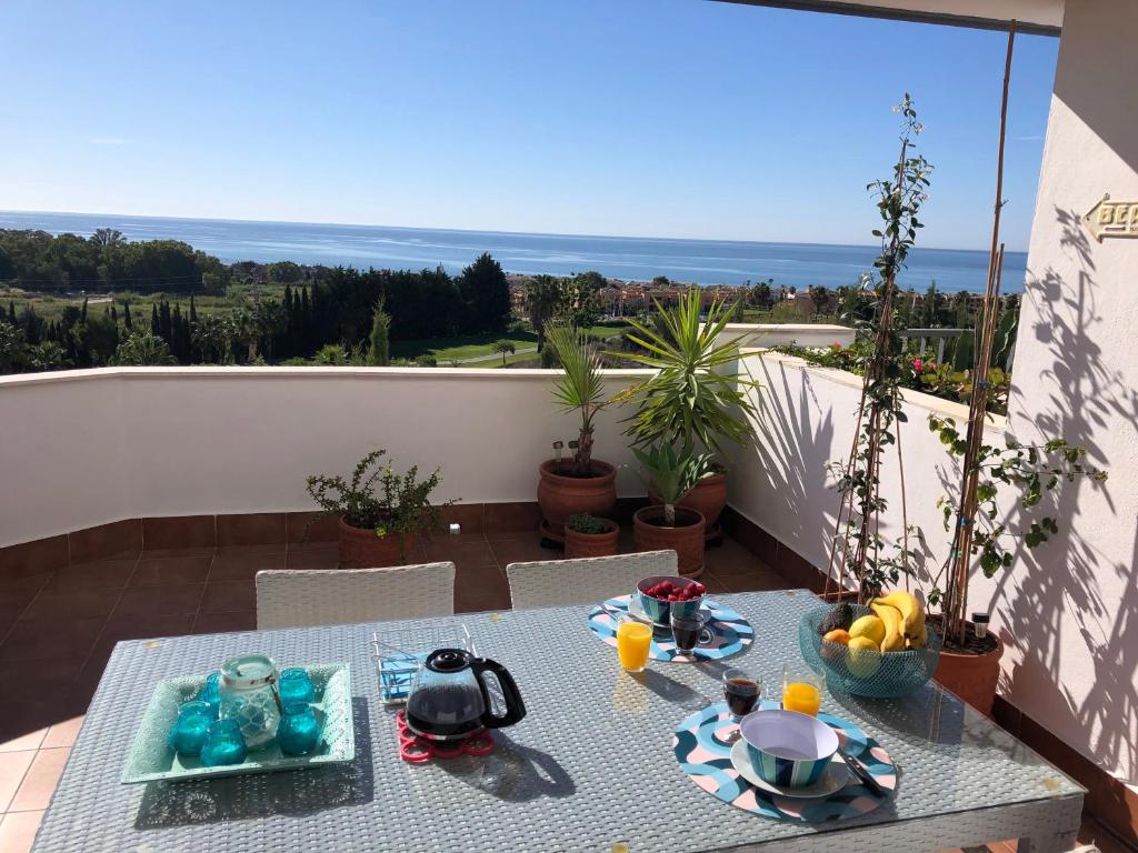 a table on a balcony with a view of the ocean at La casa Ana in Casares