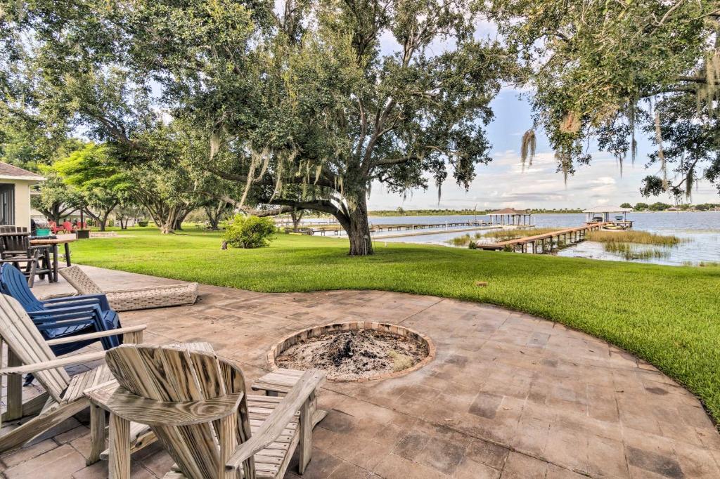 een patio met stoelen en een vuurplaats naast het water bij Waterfront Lake Placid Home with Dock and Fire Pit in Lake Placid