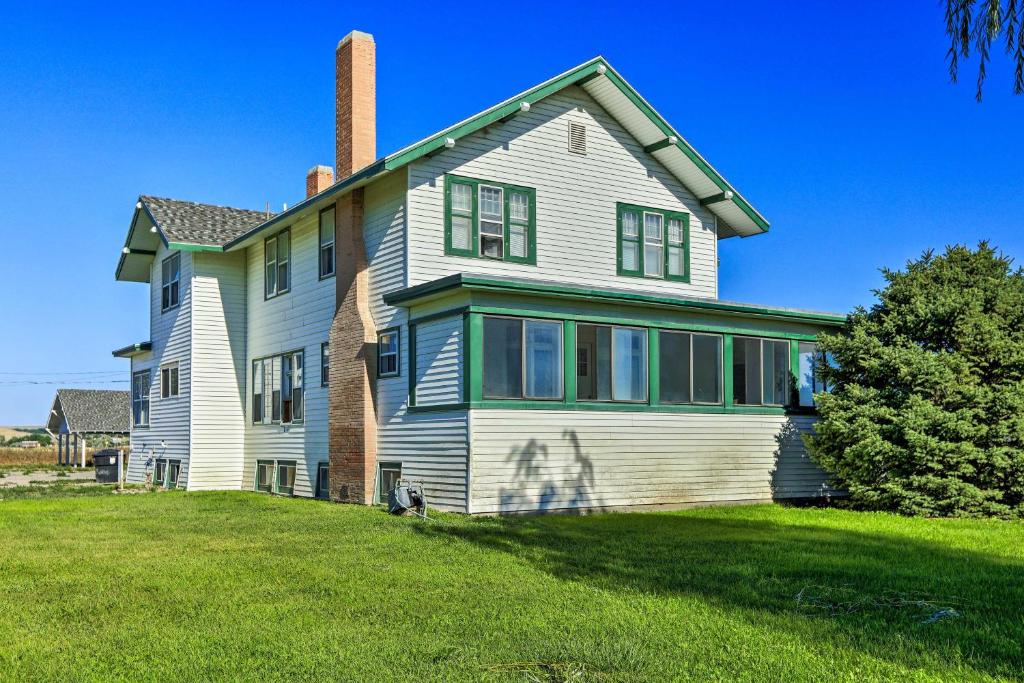 a large white house with a chimney on a lawn at Lovell Home Drive to Bighorn Mtn, Yellowstone in Lovell
